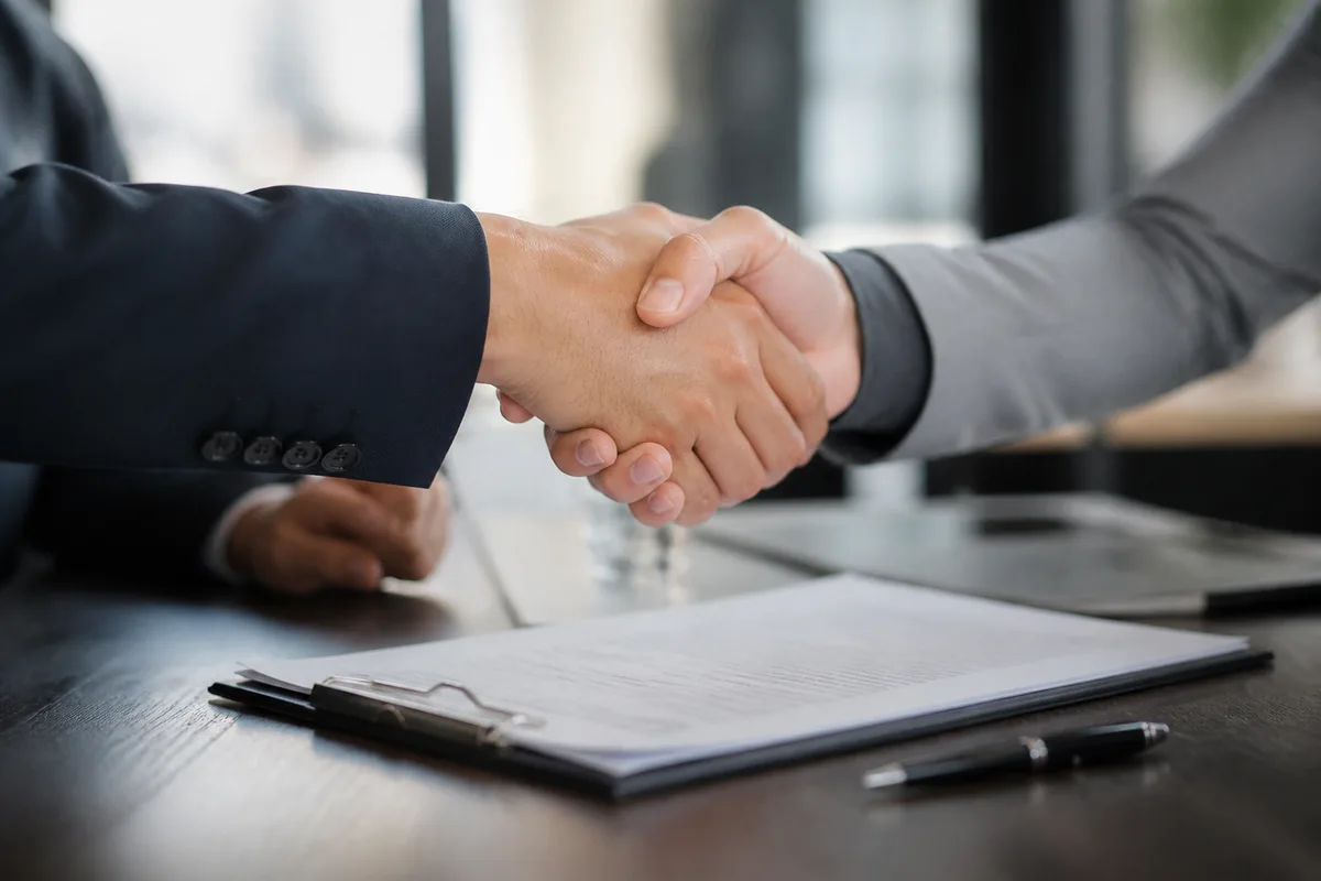 Poignée de main professionnelle au-dessus d&rsquo;un contrat sur une table de réunion